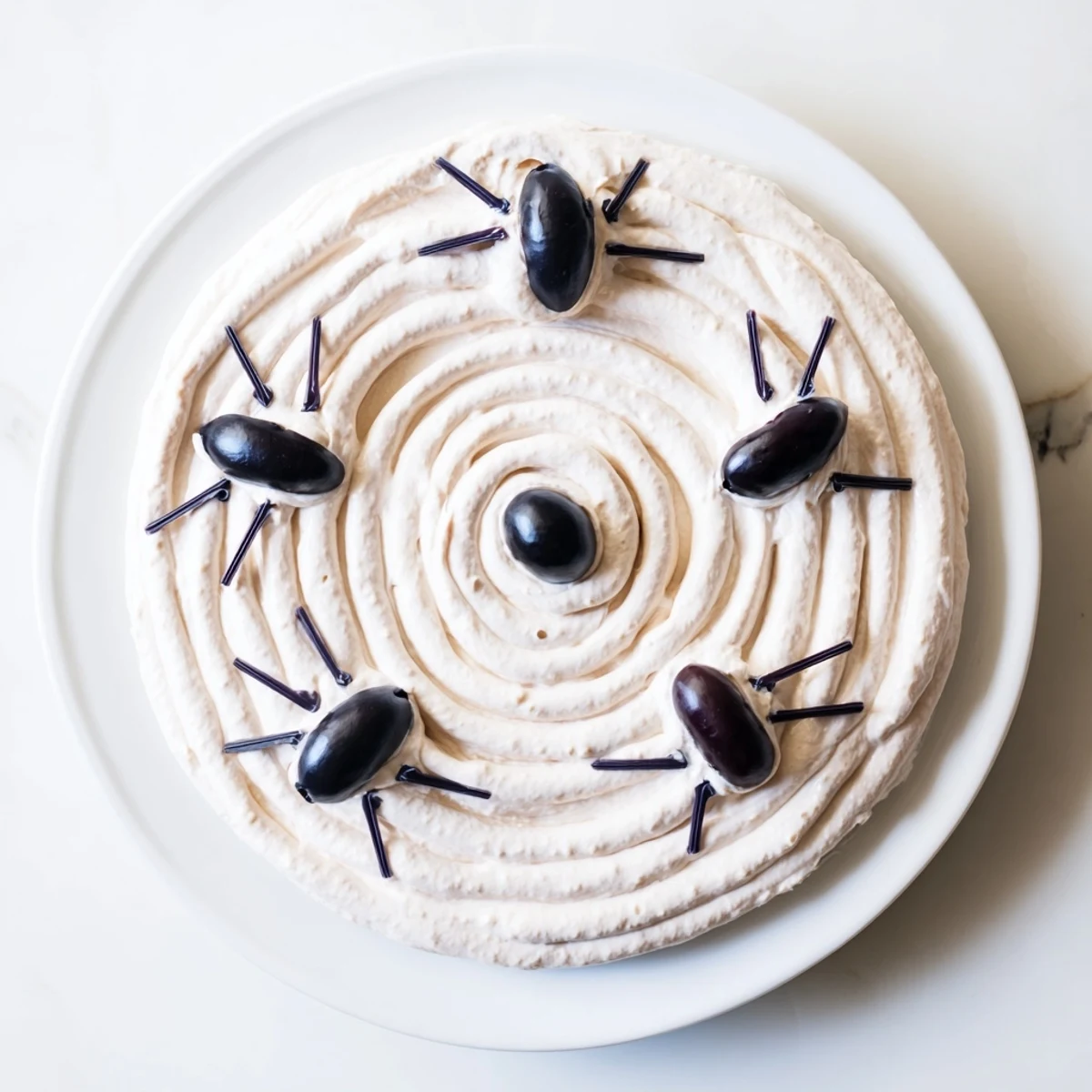 Creamy, web-shaped dip with olive spiders: This Creepy Crawly Spiderweb Platter is perfect for Halloween!