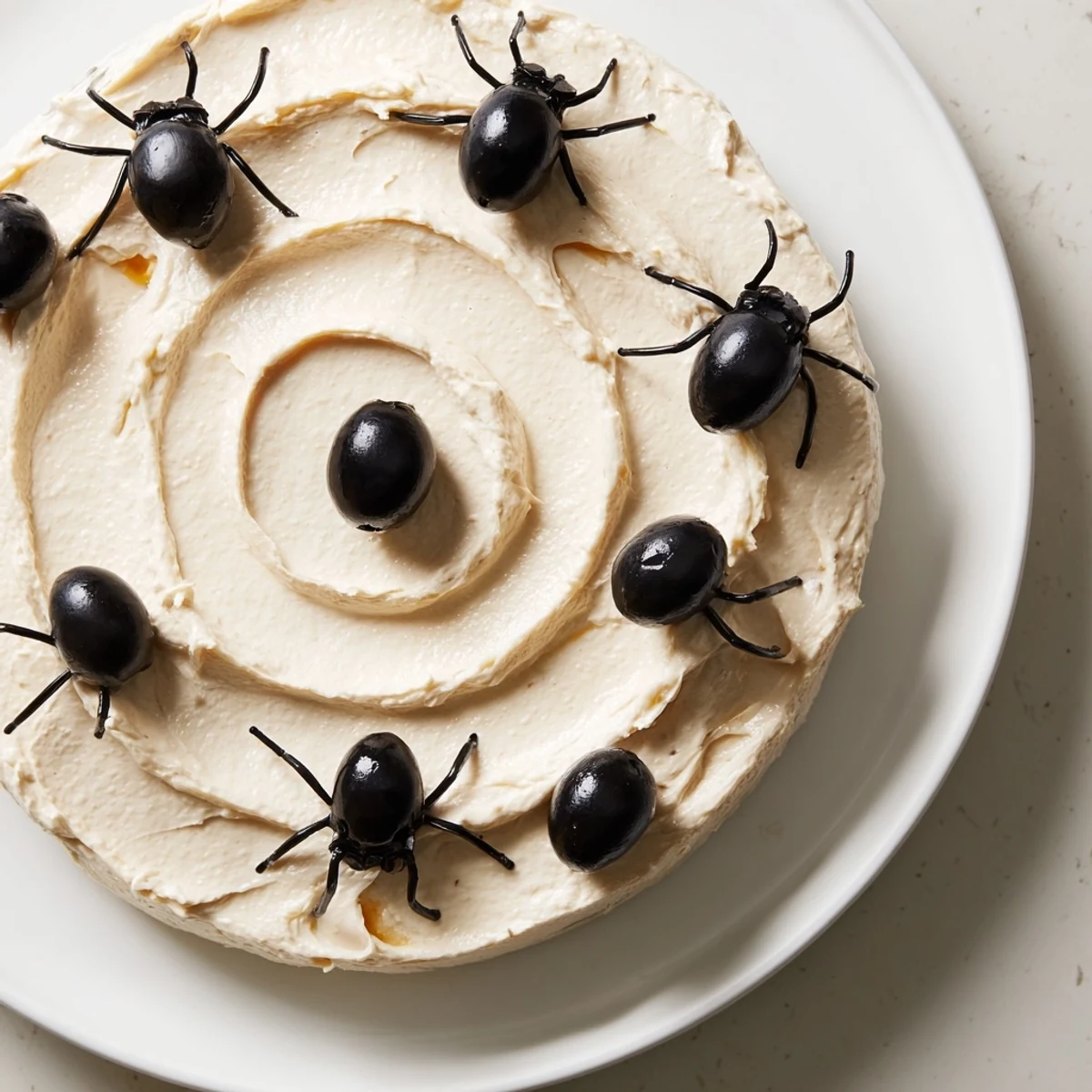 Arrange a spooky Creepy Crawly Spiderweb Platter featuring black olives and a creamy, delicious dip for your party.
