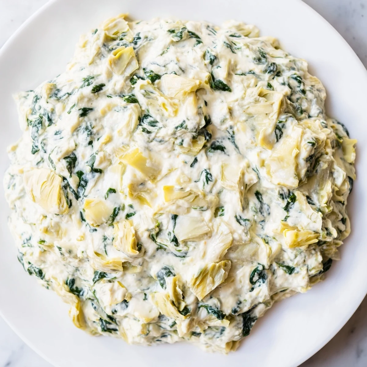 Close-up of creamy spinach artichoke dip, baked until golden brown and ready to serve.