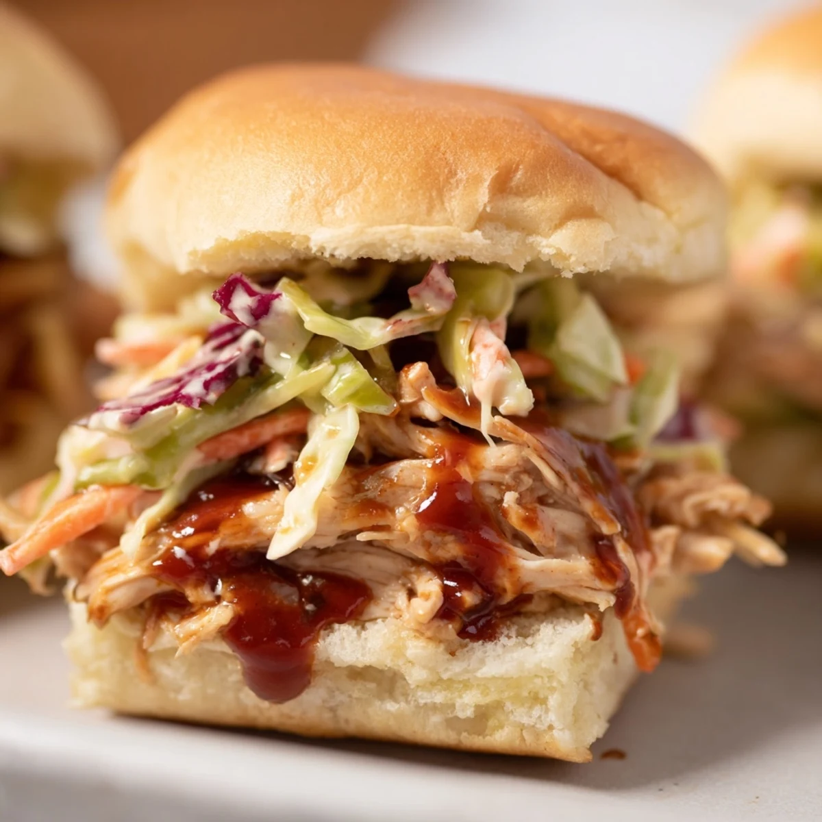 Golden, butter-toasted mini buns stuffed with juicy pulled BBQ chicken and creamy, tangy slaw.  