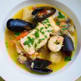Rich, flavorful bouillabaisse, a Provençal fish stew with fragrant herbs, served with toasted bread.