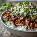 Tender pulled pork bowl with fluffy rice, tangy coleslaw, and smoky BBQ drizzle ready to serve.
