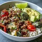 A vibrant ground turkey bowl with roasted vegetables, whole grains, fresh avocado, and lime for a balanced meal.