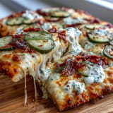 Tangy Pickle Pizza Flatbread, a savory delight with creamy garlic ranch, ready to be sliced.
