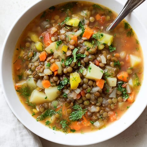 A steaming bowl of Classic Lentil and Herb Soup garnished with fresh parsley.