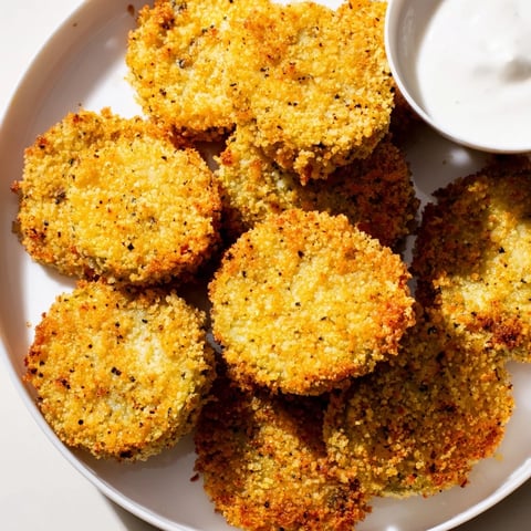 Golden-brown Crispy Fried Pickles, perfectly crunchy, served with cool ranch dressing - a delicious appetizer.