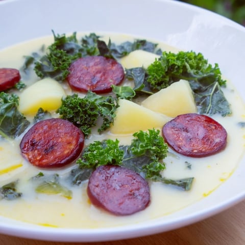 A close-up of creamy Portuguese Caldo Verde soup, brimming with kale and smoky chorizo.