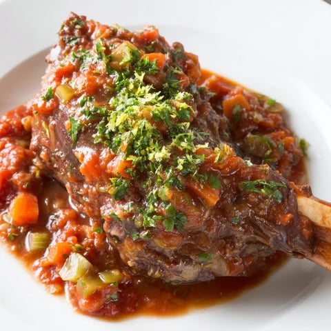 Tender Osso Buco served, showcasing rich, savory braised veal shanks and vibrant gremolata, perfect for dinner.