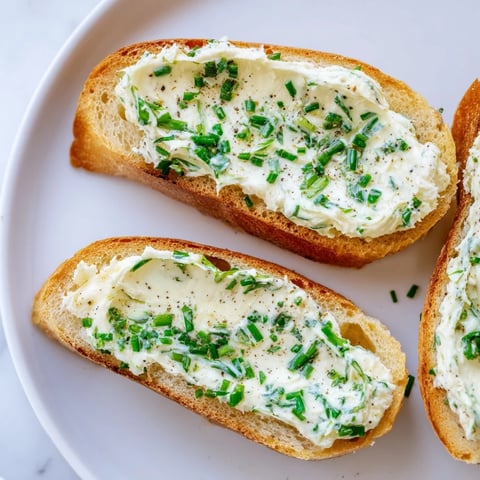 Golden, crisp vodka butter crostini arranged neatly on a serving platter with fresh chives and lemon zest.  