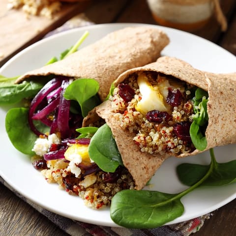 A close-up of a flavorful roasted Brussels sprouts & cranberry grain wrap, cut in half, inviting to taste.