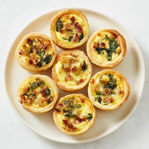 Golden, flaky mini quiche holiday village board: a delightful savory appetizer arrangement for sharing.