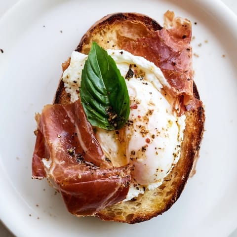 A close-up view of the crispy prosciutto and burrata grilled cheese, showing golden bread.