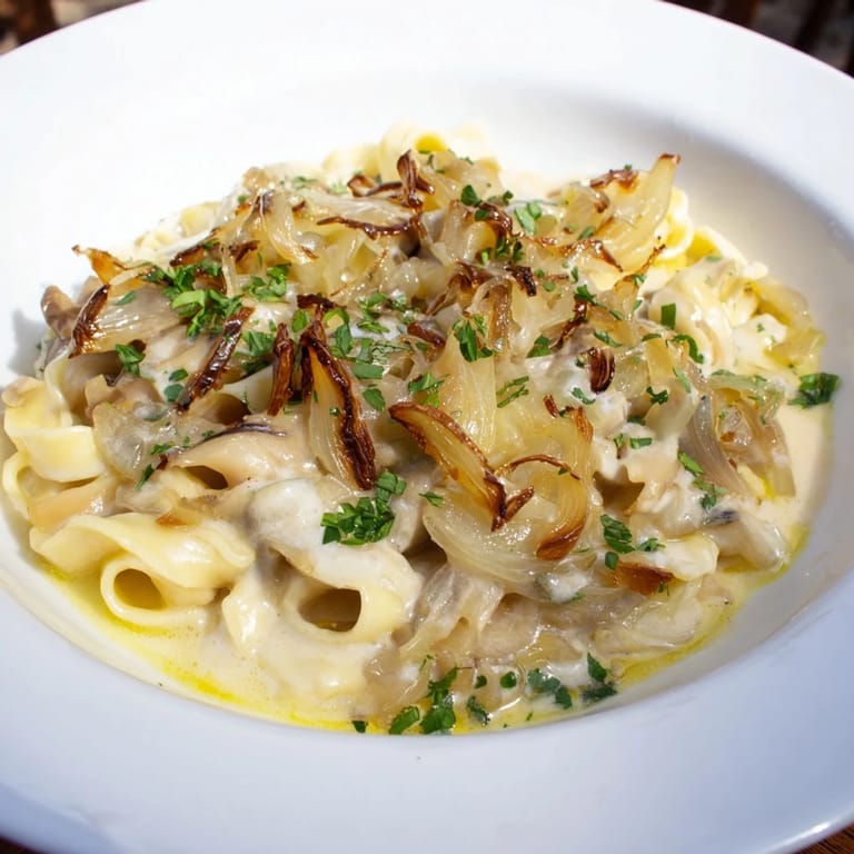 A close-up of cheesy One-Pot French Onion Pasta with caramelized onions, ready to eat and enjoy.