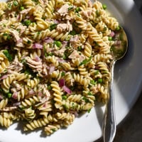 A bright bowl of Lemony Tuna Pasta Salad, showcasing flaked tuna, tender peas, and al dente fusilli tossed with fresh herbs.  