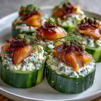 Crisp cucumber rounds topped with creamy dill-infused cream cheese and delicate smoked salmon slices—perfect for elegant appetizers.