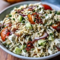 Fresh orzo salad with cucumber, feta, and zesty lemon dressing, perfect for summer gatherings.  